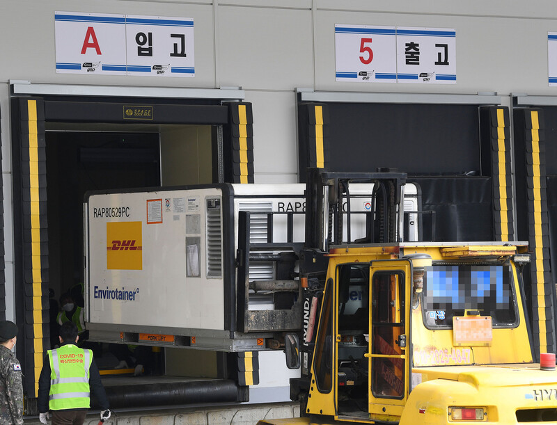 국내 첫 코로나19 백신 접종을 이틀 앞둔 24일 경기도 이천의 지트리비앤티 물류센터에서 관계자들이 경북 안동시 에스케이(SK)바이오사이언스 공장에서 위탁 생산된 아스트라제네카 백신 수송용기를 지게차를 이용해 창고로 옮기고 있다. 연합뉴스