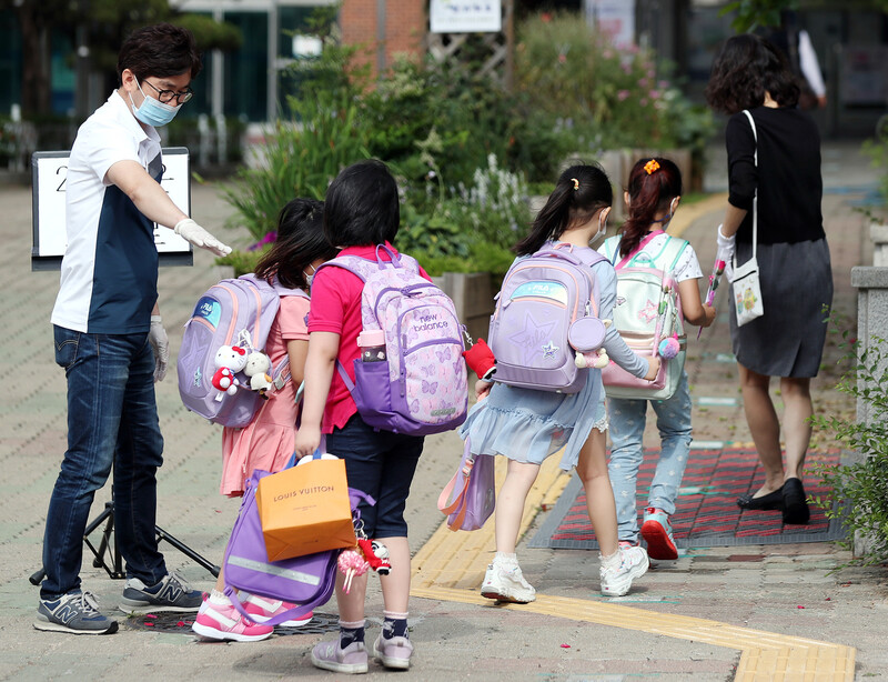 경기 부천지역 특수학교, 유치원, 초·중·고등학교(고3 제외) 등교 수업이 시작된 11일 오전 경기도 부천시 송내동 솔안초등학교에서 처음 입학한 학생들이 교사의 안내에 따라 학교 건물로 들어서고 있다. 연합뉴스