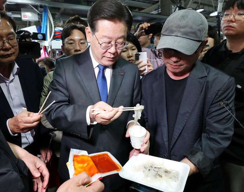 이재명 더불어민주당 대표가 22일 강원 강릉시 주문진 좌판풍물시장에서 오징어를 시식하고 있다. 연합뉴스