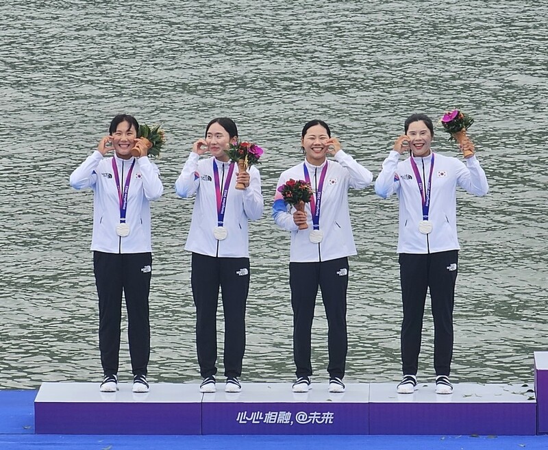 카누 국가대표 이한솔(왼쪽부터), 조신영, 최란, 이하린이 3일 중국 항저우 푸양 수상스포츠센터에서 열린 2022 항저우아시안게임 카누 스프린트 여자 카약 4인승 500m에서 은메달을 딴 뒤 시상대에서 볼 하트를 하고 있다. 대한카누연맹 제공