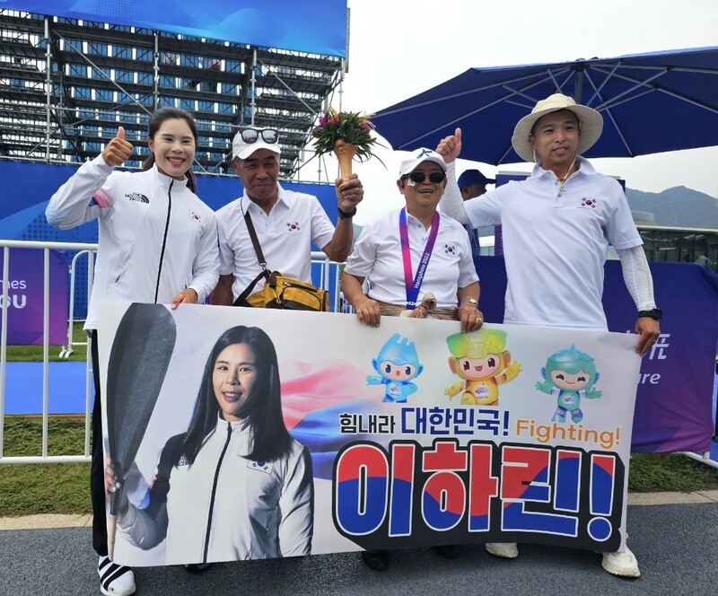 이하린(왼쪽부터)과 아버지 이기태씨, 어머니 홍계순씨, 직업군인인 남편 김부용씨가 3일 중국 항저우 푸양 수상스포츠센터에서 열린 2022 항저우아시안게임 카누 스프린트 여자 카약 4인승 500m 시상식 뒤 가족들이 직접 만든 응원 걸개를 들고 사진을 찍고 있다. 대한카누연맹 제공