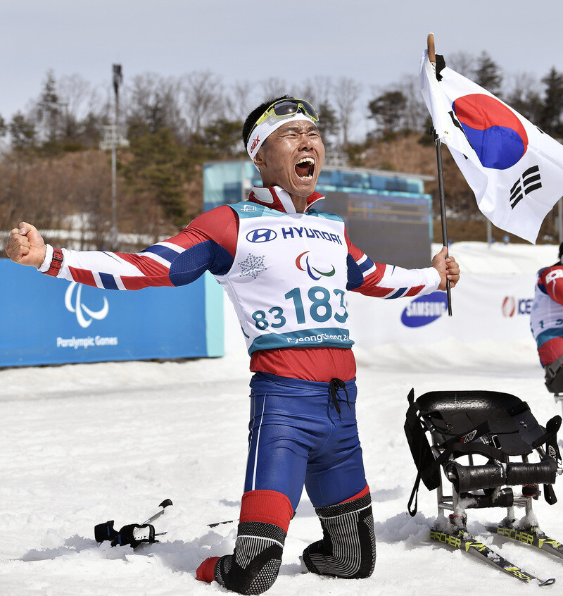 2018 평창겨울패럴림픽에 출전했던 신의현이 태극기를 들고 포효하고 있다. 평창에서 크로스컨트리 스키 좌식 금메달(7.5㎞)과 동메달(15㎞)을 목에 걸었던 신의현은 이번 대회에서 2연속 금메달을 노린다. 브라보앤뉴 제공