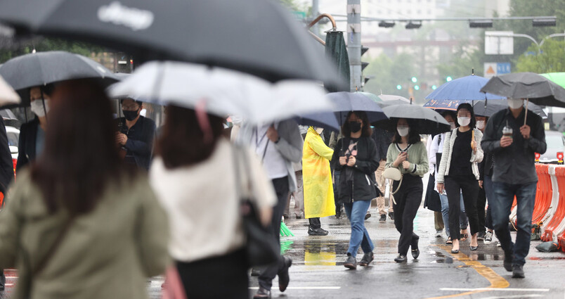 전국 대부분 지역에 비가 내리는 27일 오전 서울 광화문 광장에서 시민들이 우산을 쓰고 걸어가고 있다. 연합뉴스