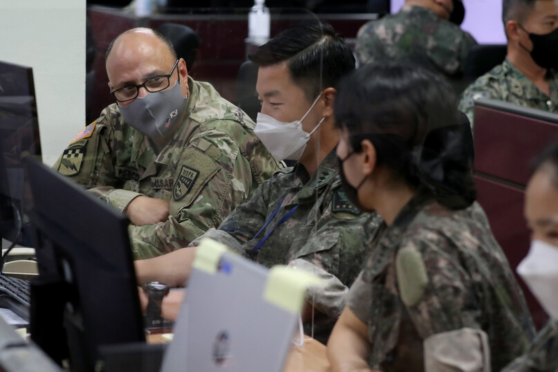 지난 23일 한미연합군사령부 전시지휘소(시피 탱고)에서 한미 장병들이 ‘을지 자유의 방패’ 연습을 하고 있다. 시피 탱고는 경기 성남에 있는 한미연합사 지하벙커다. 국방부가 제공한 이 사진은 공격헬기와 전차가 다급하게 출동하는 조간신문들 1면 사진(아래)과는 분위기가 다르다. 어느 모습이 한미연합연습의 본질일까. 국방부 제공