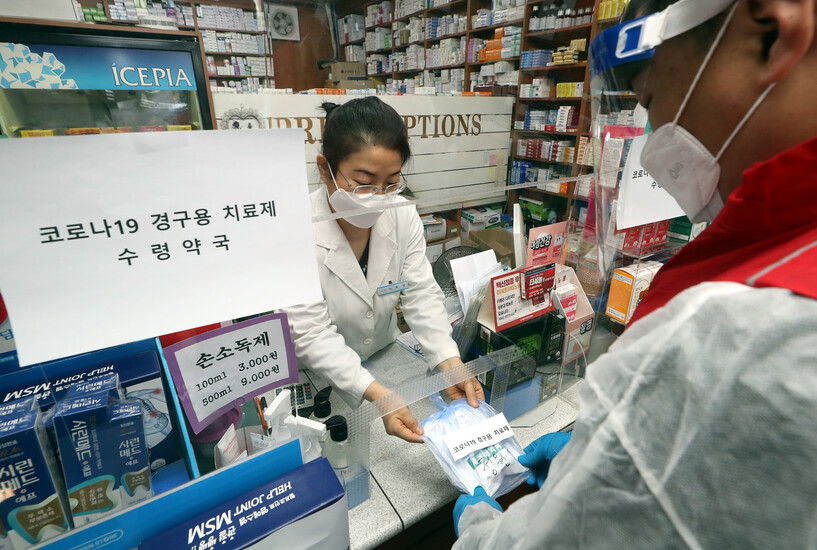 12일 오전 인천시 부평구 한 약국에서 열린 ‘코로나19 경구용(먹는) 치료제 투약 예행 연습'에서 부평구보건소 관계자가 치료제를 약국에서 수령해 환자에게 전달하는 연습을 하고 있다. 정부는 코로나19 경구용 치료제를 이달 14일부터 각 환자에게 투약할 방침이다. 인천/연합뉴스