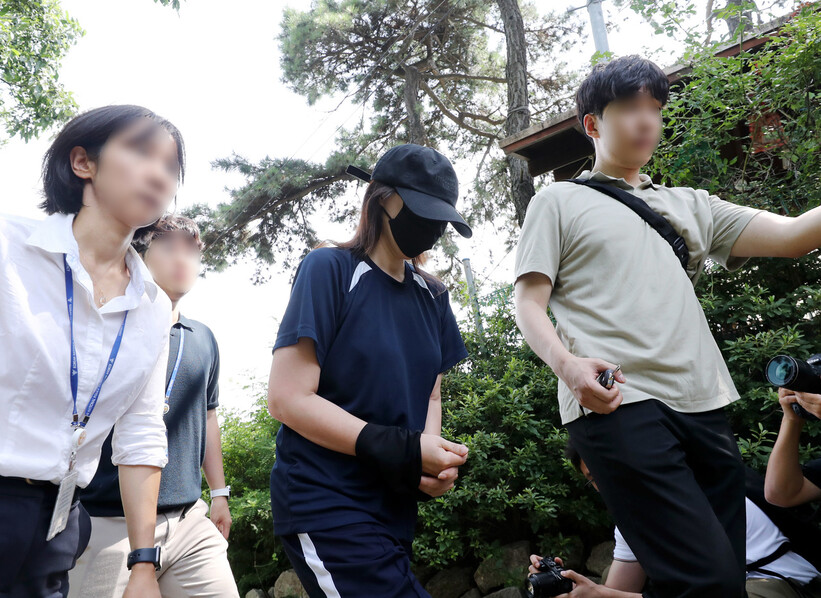 6일 오후 경기 김포시 한 텃밭 입구에서 태어난 지 하루 된 딸을 암매장한 혐의를 받는 40대 여성이 현장 검증을 마치고 이동하고 있다. 연합뉴스