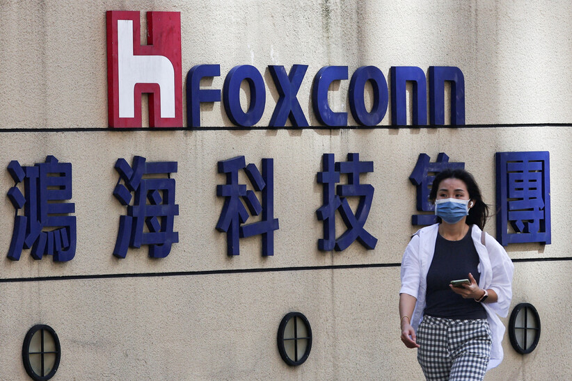 지난해 11월 대만 타이베이에 있는 폭스콘 회사의 로고 앞을 한 여성이 지나가고 있다. 타이베이/로이터 연합뉴스