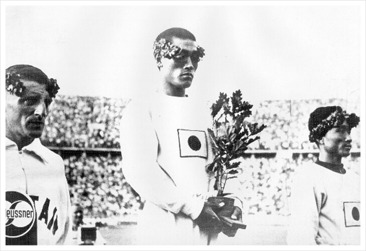1936년 베를린 올림픽 마라톤 시상대에서 손기정 선수가 부상으로 받은 참나무 화분을 들고 있다. 나중에 이 사진의 일장기를 삭제한 사진을 동아일보 등에서 실어 정간사태가 났다. 오른쪽은 3위를 한 남승룡 선수이다.