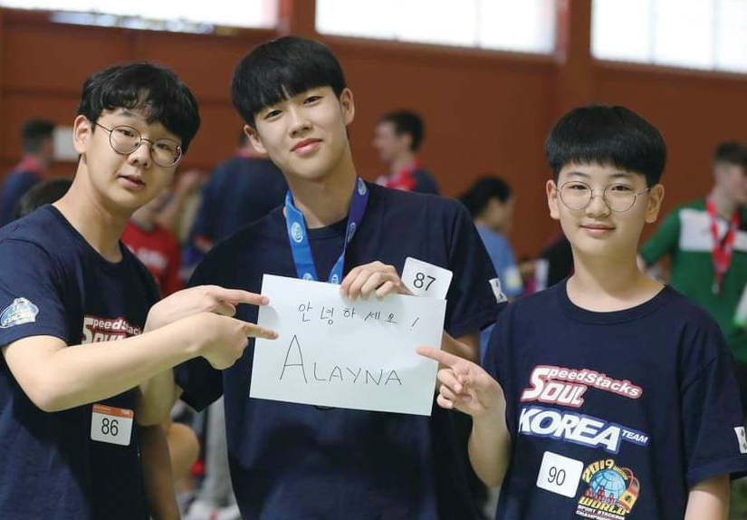 2019 스페인 월드챔피언십에 참가한 우리들. 세계협회 회장님의 부탁으로스페인어로 ‘안녕하세요’가 적힌 종이를 들고 환히 웃고 있어. 사진 제공 문성현 · 정택훈 · 조한서