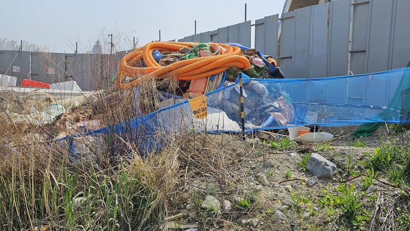 지난 21일 부산항 북항 재개발구역의 친수공원 한쪽에 폐기물이 쌓여 있는 모습. 김영동 기자