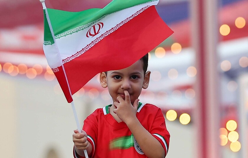 2022 카타르 월드컵 개막을 하루 앞둔 19일(현지시각) 오후 카타르 루사일 도심 상업지역을 가로지르는 큰 도로에서 이란 대표팀 유니폼을 입은 한 어린이가 국기를 들고 서 있다. 루사일/김혜윤 기자