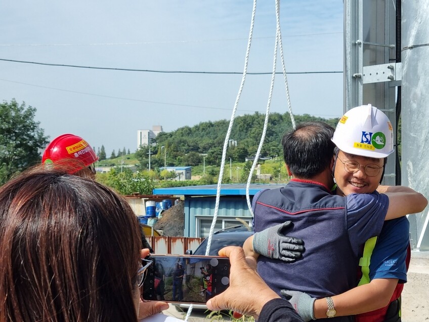 20일 오전 10시30분께 40일에 걸친 고공농성을 마치고 지상으로 내려온 김성규 전국민주일반노조 경기본부장이 조합원들과 포옹하고 있다. 에어팰리스 지부 제공