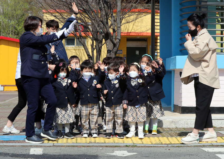 지난 25일 오전 광주 북구 어린이교통공원에서 한 유치원 원생들이 마스크를 끼고 횡단보도 앞에 서 있다. 연합뉴스