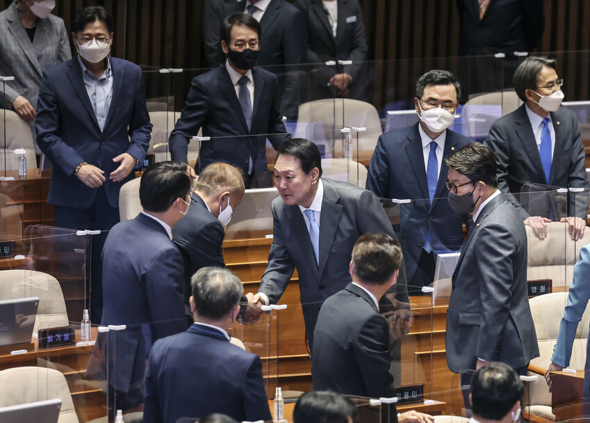 윤석열 대통령이 16일 국회 본회의장에서 코로나19 손실보상을 위한 추가경정예산(추경)안에 대해 시정연설을 마친 뒤 퇴장하며 의원들과 인사하고 있다. 공동취재사진