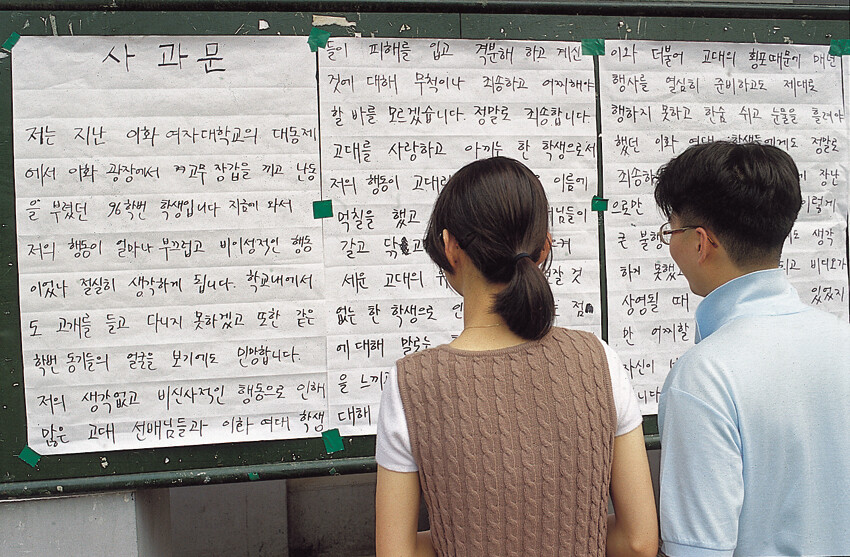 결국 고대생은 이화여대에 사과문을 남겼다. “저는 지난 이화여자대학교의 대동제에서 이화광장에서 고무장갑을 끼고 난동을 부렸던 96학번 학생입니다”라고 적혀 있다. 이화여대 학생이 이를 읽고 있다. 가해자는 고려대의 이름에 먹칠했다는 점을 후회하고 있다. 이 사진은 1996년 6월 &lt;한겨레21&gt;에 실렸다. 박승화 기자가 촬영했다.