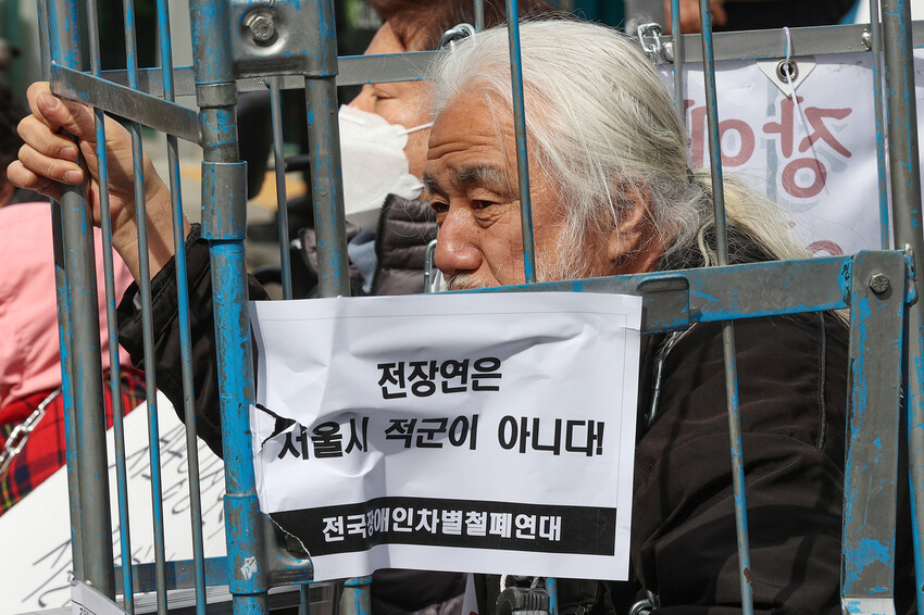 박경석 전국장애인차별철폐연대(전장연) 상임공동대표가 지난 17일 오전 서울 종로구 서울경찰청 앞에서 체포영장 발부에 관해 입장을 밝히는 기자회견에 참석해 있다. 지난 15일 남대문경찰서는 기차교통방해·업무방해·집회 및 시위에 관한 법률 위반 혐의로 박 대표에 대한 체포영장을 신청했고, 전날 오후 법원으로부터 영장을 발부받은 바 있다. 연합뉴스