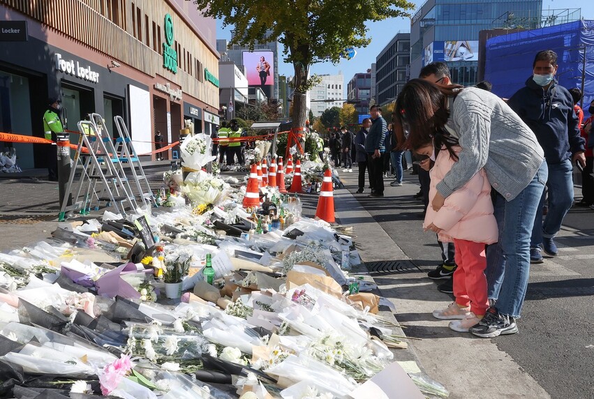 6일 서울 용산구 이태원역 1번 출구 앞 참사 추모 공간을 찾은 한 가족이 희생자를 추모하고 있다. 연합뉴스