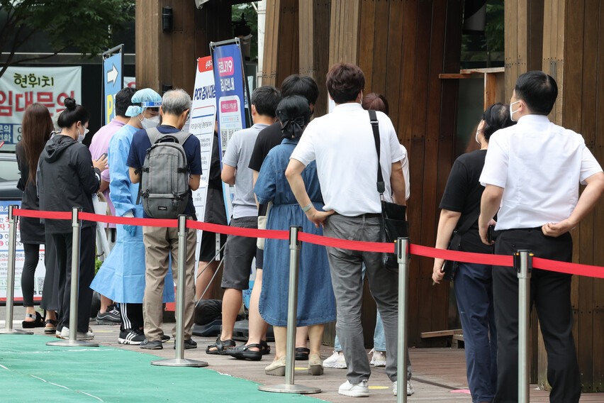 코로나19 신규 확진자 수가 3만9196명을 기록한 14일 오전 서울 송파구 보건소 선별검사소에서 시민들이 줄을 서서 검사 순서를 기다리고 있다. 연합뉴스.