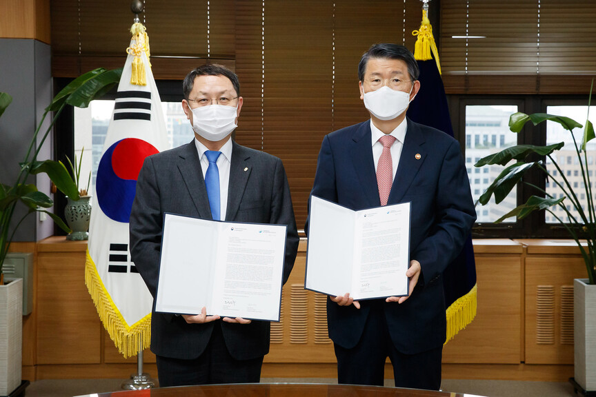 은성수 금융위원장(오른쪽)과 김근익 금융감독원장 직무대행(왼쪽)이 녹색금융협의체(NGFS) 가입 신청 서한에 서명한 뒤 기념사진을 찍고 있다. 사진 금융위원회 제공