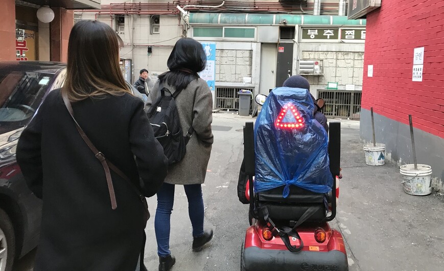 전동휠체어를 타고 이동하는 권나영씨와 정주희(왼쪽 앞), 김희주 감독.