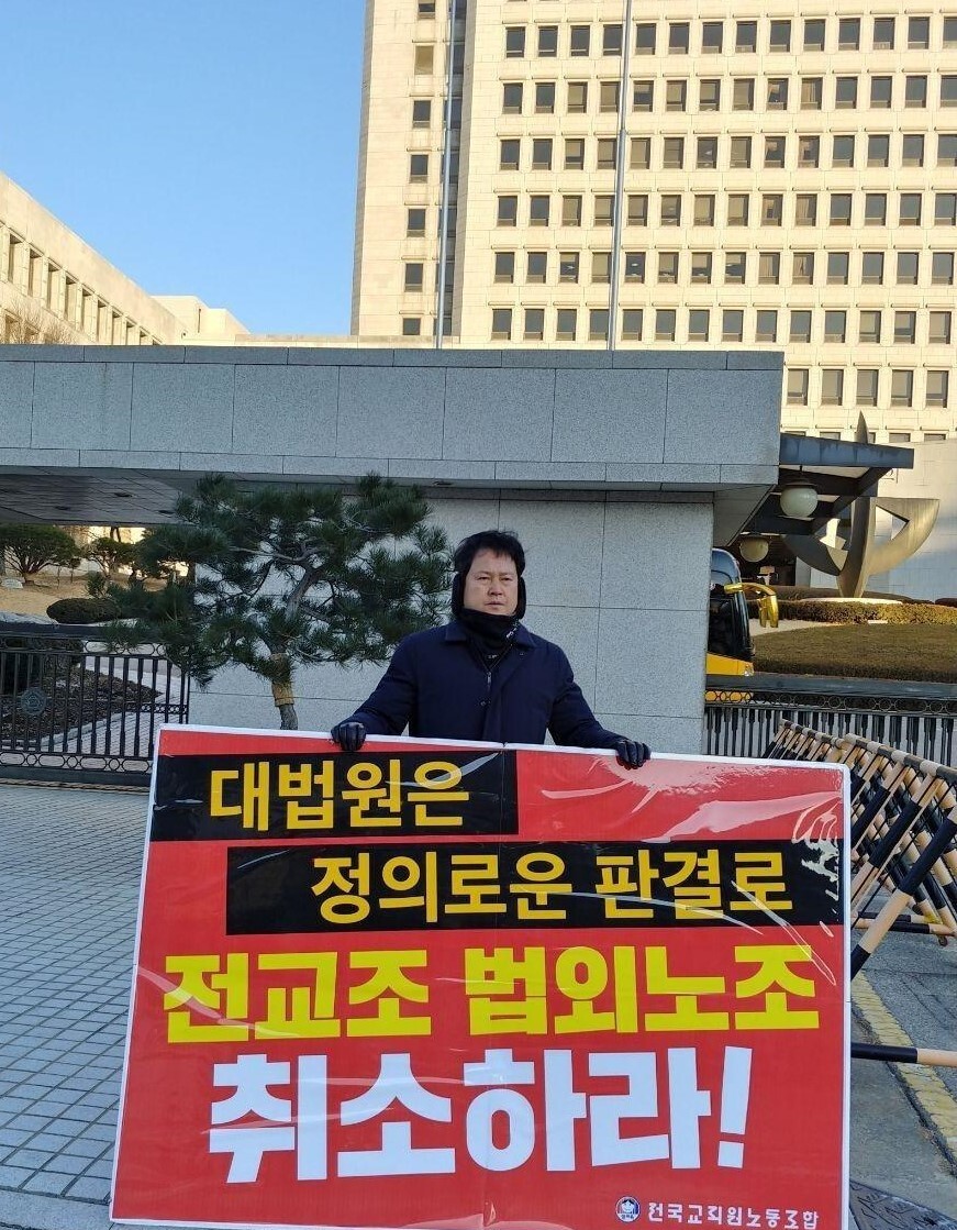 권정오 전교조 위원장이 지난 6일 오전 서울 서초동 대법원 정문 앞에서 “전교조 법외노조 취소하라”고 쓴 팻말을 내걸고 1인시위를 하고 있다. 전교조 제공