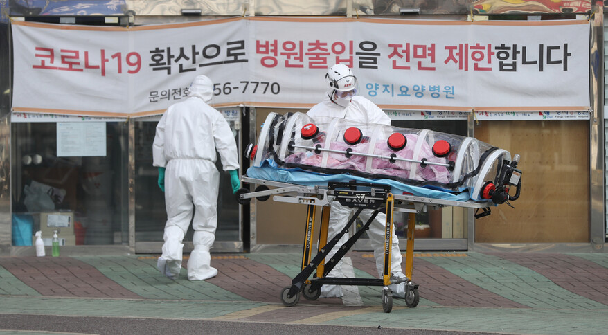 7일 오전 코로나19 확진자가 무더기로 발생한 울산시 남구 양지요양병원 앞에서 소방대원들이 확진자를 구급차로 옮기고 있다. 이 병원에서는 이틀간 91명의 확진자가 나왔다. 연합뉴스