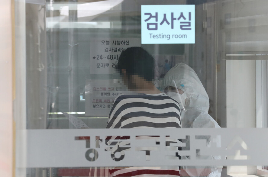 17일 오후 서울 강동구보건소에 마련된 선별진료소에서 시민들이 코로나19 검사를 받기 위해 의료진의 안내를 받고 있다. 연합뉴스