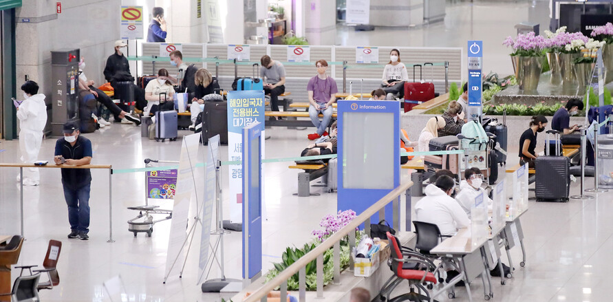 12일 오후 인천국제공항 제1여객터미널을 통해 입국한 해외입국자들이 수송 교통편을 기다리고 있다. 연합뉴스