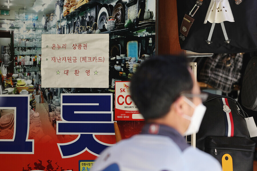 지난달 24일 오후 서울 중구 남대문시장의 한 매장에 붙어있는 재난지원금 사용 가능 안내문. 연합뉴스