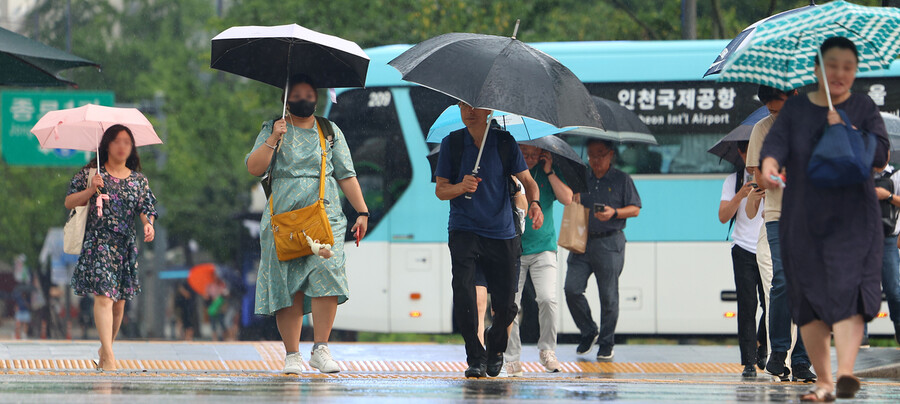 지난 8월 소나기가 내린 서울 세종로사거리에서 우산을 쓴 시민들이 길을 지나고 있다. 연합뉴스