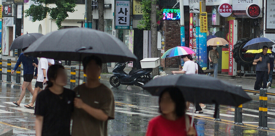 경남도가 장마철에 접어든 25일 오후 경남 창원시 마산합포구 한 거리에서 시민들이 우산을 쓴 채 걷고 있다.연합뉴스