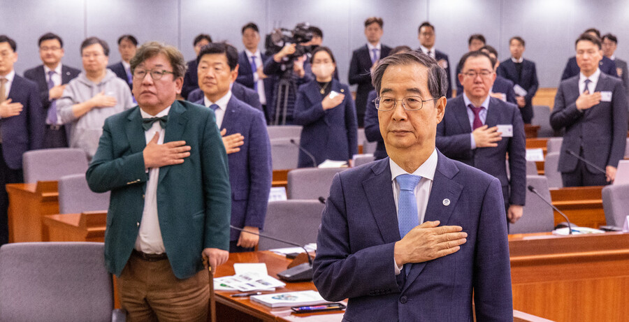 한덕수 국무총리가 10일 오후 서울 종로구 정부서울청사 별관에서 열린 ‘2050 탄소중립 녹색성장위원회’ 전체회의에서 참석해 국기에 경례하고 있다. 연합뉴스