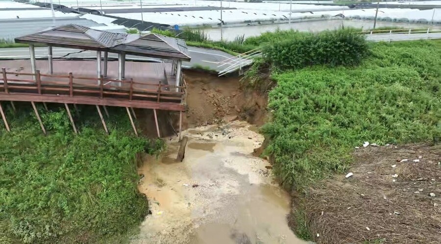 사흘째 이어진 기록적인 폭우로 지난 16일 오전 충남 논산시 성동면 우곤리 인근 금강 제방이 유실됐다. 사진은 금강과 우곤리 마을 사이에 놓인 제방이 무너져내리는 모습. 연합뉴스