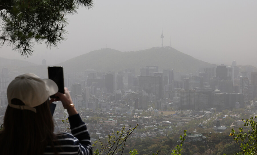 중국발 황사의 영향으로 12일 전국의 미세먼지 농도가 ‘매우 나쁨’ 수준을 보인 가운데, 한 시민이 서울 종로구 북악산에서 뿌옇게 흐려진 하늘 너머로 보이는 남산 타워를 휴대폰 카메라에 담고 있다. 신소영 기자 viator@hani.co.kr