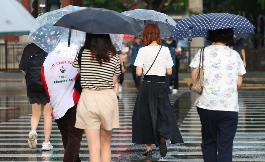 22일 오후 서울 세종로사거리에서 우산을 쓴 시민들이 길을 지나고 있다. 연합뉴스