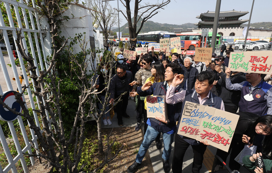 기후위기비상행동 등 기후·환경단체 회원들이 10일 정부서울청사 앞에서 ‘탄소중립녹색성장 기본계획 규탄 기자회견’을 열고 청사 내부로 씨앗 뭉치를 던지는 퍼포먼스를 하고 있다. 연합뉴스