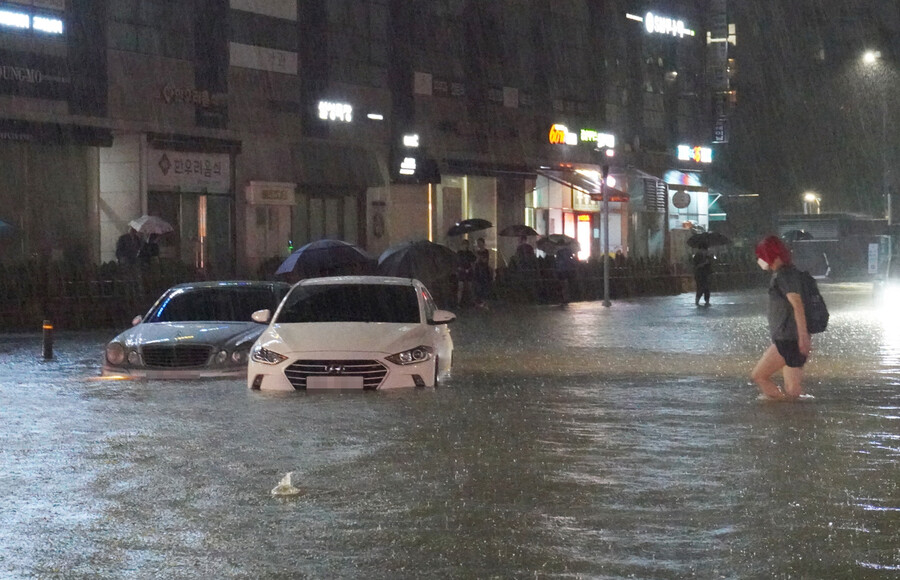 폭우가 쏟아진 지난 8일 밤 서울 강남구 대치동 은마아파트 부근 도로와 인도가 물에 잠기면서 차량과 보행자가 통행하는 데 불편을 겪고 있다. 연합뉴스