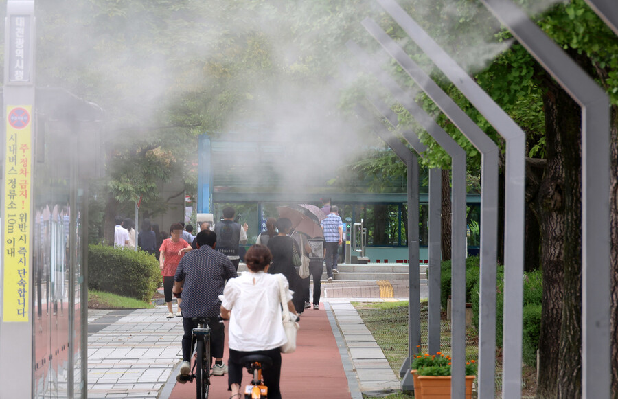 5일 오후 대전시 서구 둔산동 대전시청 앞에 설치된 쿨링포그 아래로 시민들이 지나가고 있다.연합뉴스