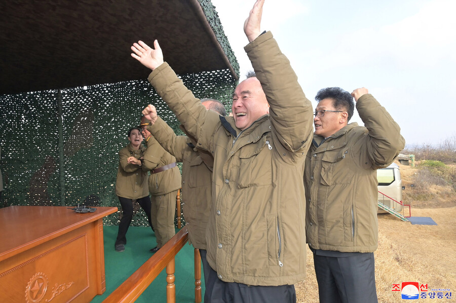 지난 18일 평양국제비행장(순안비행장)에서 이뤄진 신형대륙간탄도미사일 ‘화성포-17형’ 발사 ‘성공’ 확인 직후 조용원 조선노동당 중앙위 정치국 상무위원 등 고위 관부들이 환호하는 모습. 사진 맨 왼쪽에 울부짖듯 기뻐하는 이가 김여정 노동당 중앙위 부부장이다. 조선중앙통신 연합뉴스