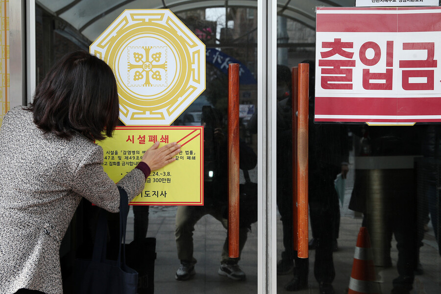 경기도 관계자가 24일 한 신천지 교회에 시설폐쇄를 알리는 공고문을 붙이고 있다. 경기도 제공