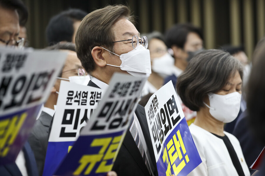 이재명 더불어민주당 의원(가운데)이 11일 의원총회에서 윤석열 정부를 비판하는 손팻말을 들고 있다. 공동취재사진