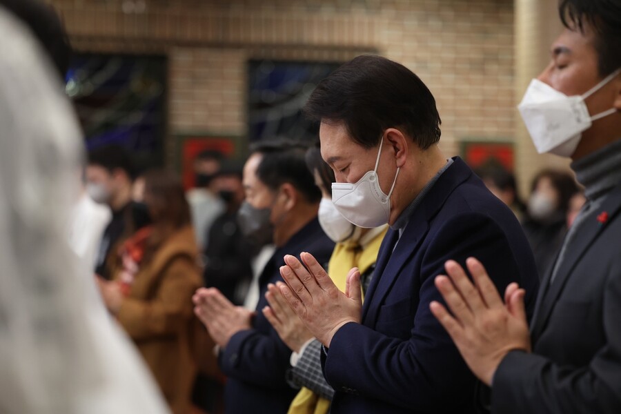 윤석열 대통령과 김건희 여사가 24일 저녁 서울 중구 약현성당에서 ‘주님 성탄 대축일 미사’에 참석해 두손을 모아 기도하고 있다. 대통령실 제공