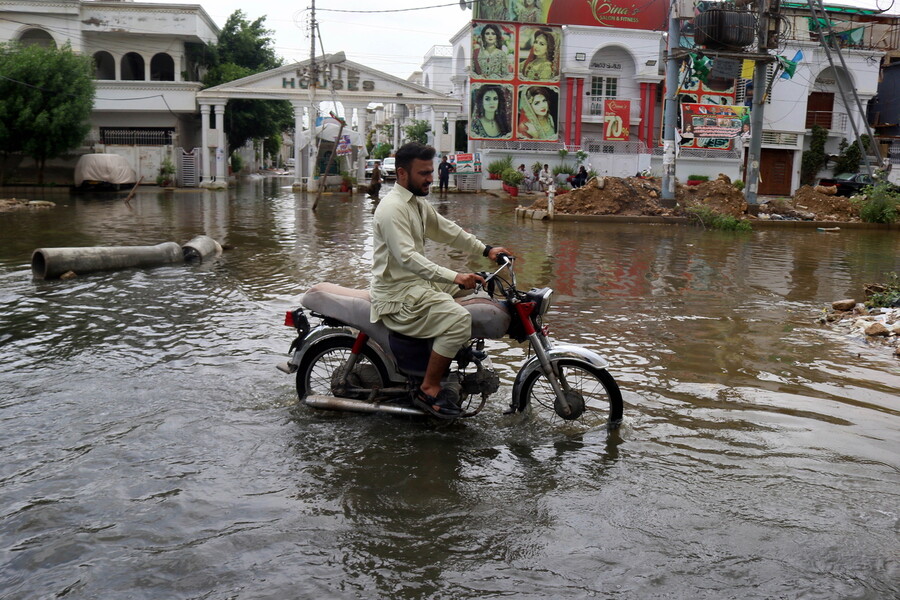 지난해 7월 대홍수가 난 파키스탄 카라치에서 한 남성이 오토바이를 타고 가고 있다. 카라치/EPA 연합뉴스