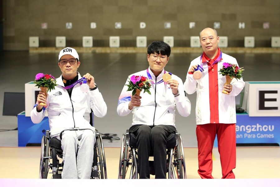 이장호(가운데)와 박진호(왼쪽)가 23일 중국 항저우 푸양 인후 스포츠센터에서 열린 2022 항저우 장애인아시안게임 사격 R1(SH1 남자 10ｍ 공기소총 입사) 시상식에서 각각 금, 은메달을 들어보이고 있다. 대한장애인체육회 제공