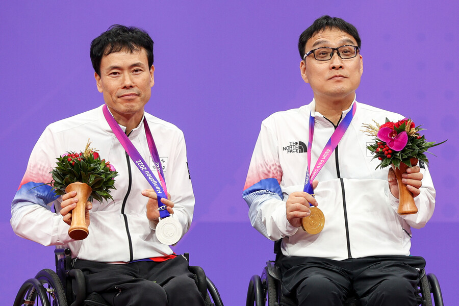 주영대(오른쪽)가 25일 중국 항저우의 궁수 캐널 스포츠센터 체육관에서 열린 2022 항저우장애인아시안게임 탁구 남자 단식 클래스1에서 우승한 뒤 은메달을 따낸 남기원과 포즈를 취하고 있다. 대한장애인체육회 제공