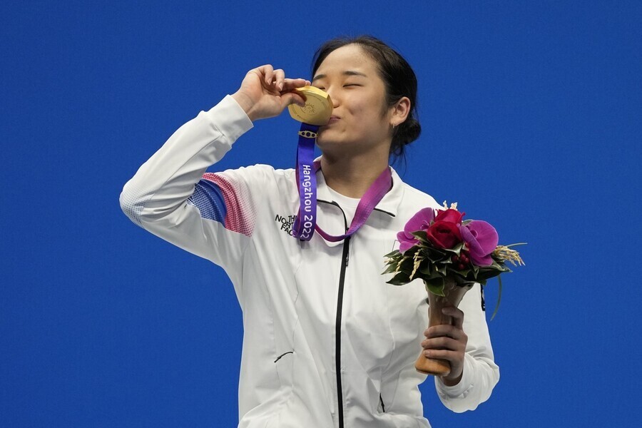 안세영이 10얼월7일 ‘2022 항저우 아시안게임’ 배드민턴 여자 단식에서 우승한 뒤 금메달에 입을 맞추고 있다. AP 연합뉴스