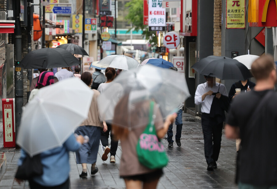 비가 내린 21일 오전 우산을 쓴 시민들이 서울 명동 거리를 지나고 있다.연합뉴스