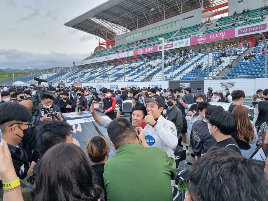 김재현(볼가스 모터스포츠)이 그리드 워크 행사에서 팬들에게 둘러싸여 기념촬영을 하고 있다. 박강수 기자