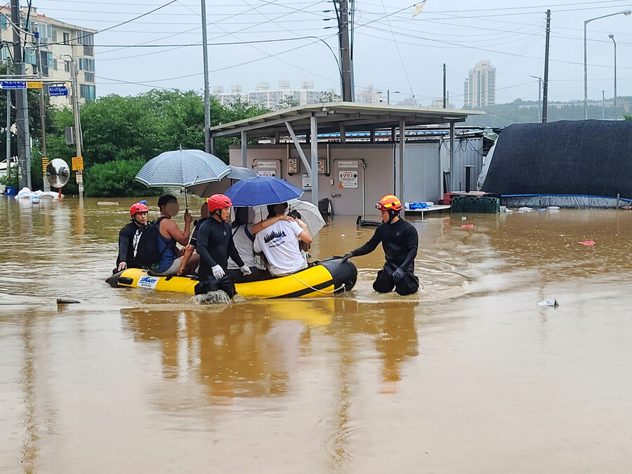 15일 많은 비로 침수 피해가 발생한 충남 공주시 옥룡동 주택 단지에서 119 대원들이 보트를 이용해 구조작업을 벌이고 있다. 연합뉴스