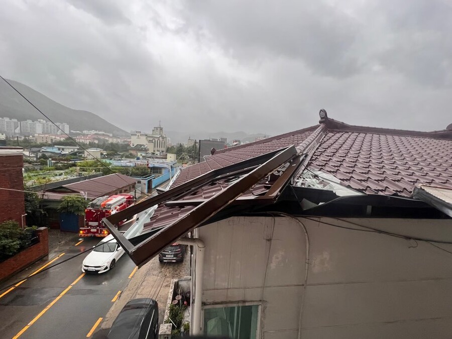 제6호 태풍 '카눈'이 북상 중인 10일 오전 전남 여수시 미평동 주택가에서 창틀이 추락해 인근 세대 지붕에 걸려 있다. 인명 피해는 없었다. 전남소방본부 제공